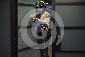 Cop Aiming Rifle While Standing At Door