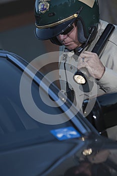 Cop With Flashlight Investigating Car