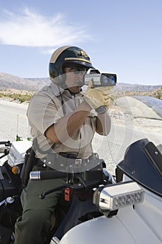 Cop Monitoring Speed Though Radar Gun photo