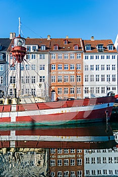 boat and houses reflected in water at Nyhavn pier, copenhagen, denmark