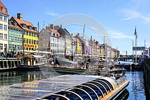 Copenhagen, Denmark- May 30, 2023: Several boats full of tourists maneuver in Nyhavn harbor canal