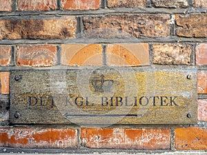 Weathered brass plate showing direction to the Royal Library Bibliotek