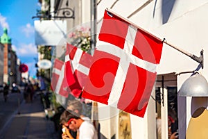 Copenhagen iconic view. Denmark flags near Nyhavn canal on medieval houses in the center of Copenhagen, Denmark during summer