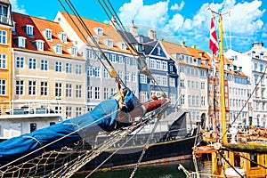 Copenhagen iconic view. Famous old Nyhavn port in the center of Copenhagen, Denmark during summer sunny day with a boat on the