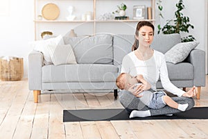 Coping With Motherhood Stress. Young Mom Breastfeeding Baby And Meditating At Home