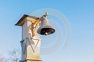 Copper bell on a wooden post, signal bell. Antique devices for warning of misfortune, gathering people, alarm. Beautiful old metal