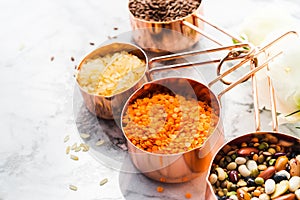 Copper cups with beans and cereal on marble