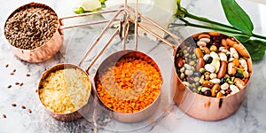 Copper cups with beans and cereal on marble