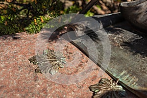 Copper forged maple leaf on granite stone