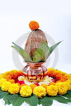 Copper Kalash with coconut , leaf and floral decoration on a white background. essential in hindu puja.