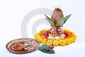 Copper Kalash with coconut , leaf and floral decoration on a white background. essential in hindu puja.