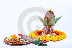 Copper Kalash with coconut , leaf and floral decoration on a white background. essential in hindu puja.