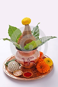 Copper Kalash with coconut , leaf and floral decoration on a white background. essential in hindu puja.