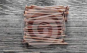 Copper nails on wooden board