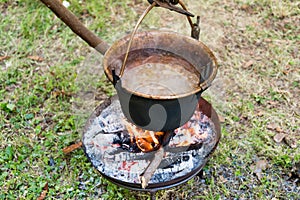 copper pan on fire with soup during a Middle Ages historic reenactment