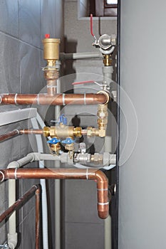 Copper pipes heating system. House heating system copper pipes.  Copper pipes of solar water heater system in boiler room