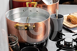 Copper pot with boiling water on a gas stove photo