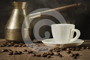 Copper pot and hot coffee cup/copper pot and hot coffee cup on a wooden table with dark background. selective focus