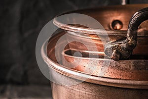 Copper pots and pans on the blurred background