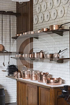 Copper pots, pans, saucepans and utensils in an old-fashioned kitchen