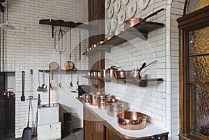 Copper pots, pans and saucepans in a vintage kitchen