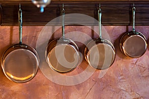 Copper saucepans set in traditional kitchen