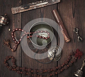 Copper singing bowl, prayer beads, prayer drum and other Tibetan religious objects for meditation and alternative medicine