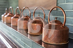 Copper teapots in a row