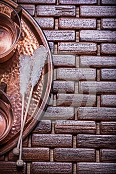 Copper tray tea cups sugar sticks on wooden