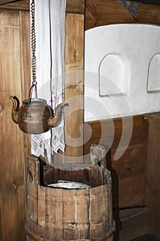 Copper vessel for drinking water kettle with two spouts in the interior of a traditional wooden house