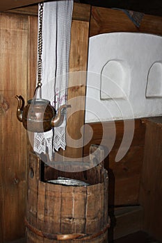 Copper vessel for drinking water (kettle with two spouts) in the interior of a traditional wooden house in the Russian North