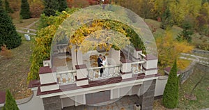 Copter view of wedding. Groom and bride walking though thw big park surrounded by forest