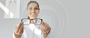 Copy space banner background with happy optometrist giving you new prescription glasses