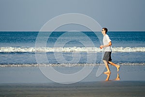 Copy space caucasian man training on the beach in morning. Young fitness male on morning run outdoors copyspace sky, sea