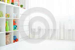 Copy the space of an empty wall in a simple children's room with a white wooden floor and a large and light window