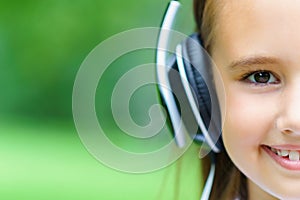 Copy space and half face of young attractive caucasian girl listening music with professional DJ headphones