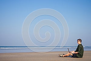 Copy space happy freelancer surfer business man with laptop relaxing on the beach.freelance and remote work.happy male