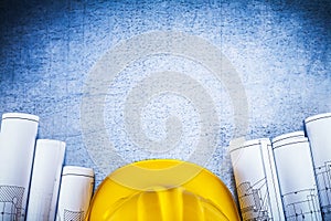 Copy space image of blueprints with protective hard hat on silve