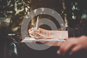 Copy space of woman hand writing down in white notebook.