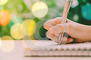 Copy space of woman hand writing down in white notebook.