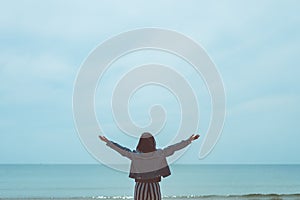 Copy space of woman rise hand up on blue sky at tropical beach and island background