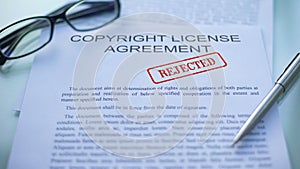Copyright license agreement rejected, officials hand stamping seal on document