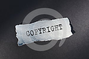 Copyright - text on torn paper on dark desk in sunlight