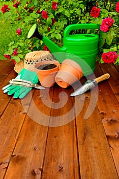 Copyspace gardening tools on wooden table and rose flowers background