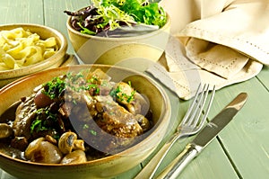 Coq au vin with salad and noodles