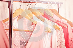 Coral womens clothes on hangers on rack in fashion store. closet