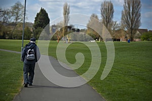 Corby, United Kingdom. March 13, 2019 - Old man walking in the autumn park. Copy space