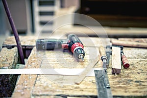 Cordless screwdriver and carpenter tools in wood industrial fact