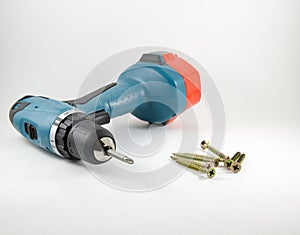 Cordless screwdriver and screws on a white background