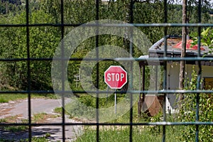 Cordoned off path in the forest with a stop sign